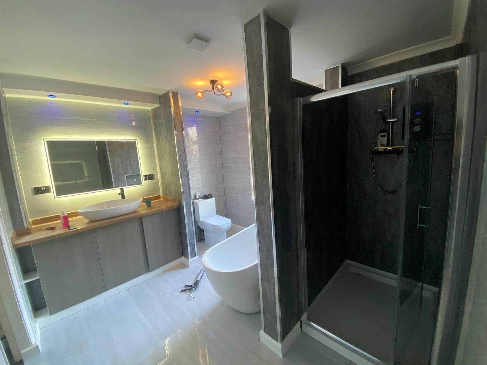 Luxury bathroom with backlit mirror and walk-in shower