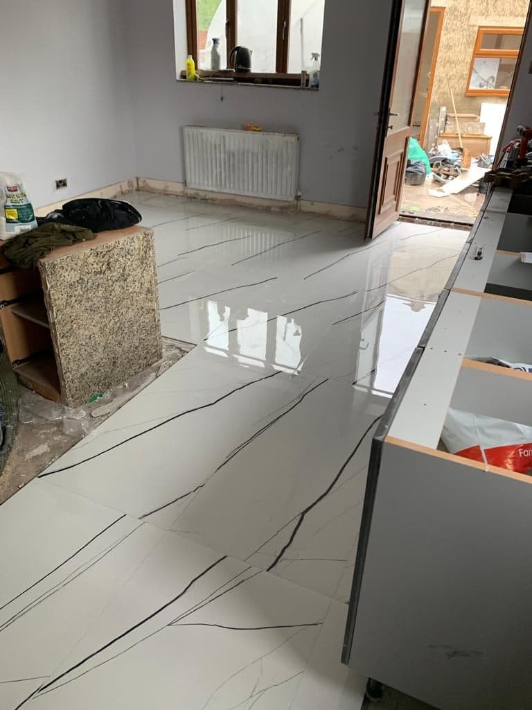 Finished marble-effect tiled floor in a UK home renovation