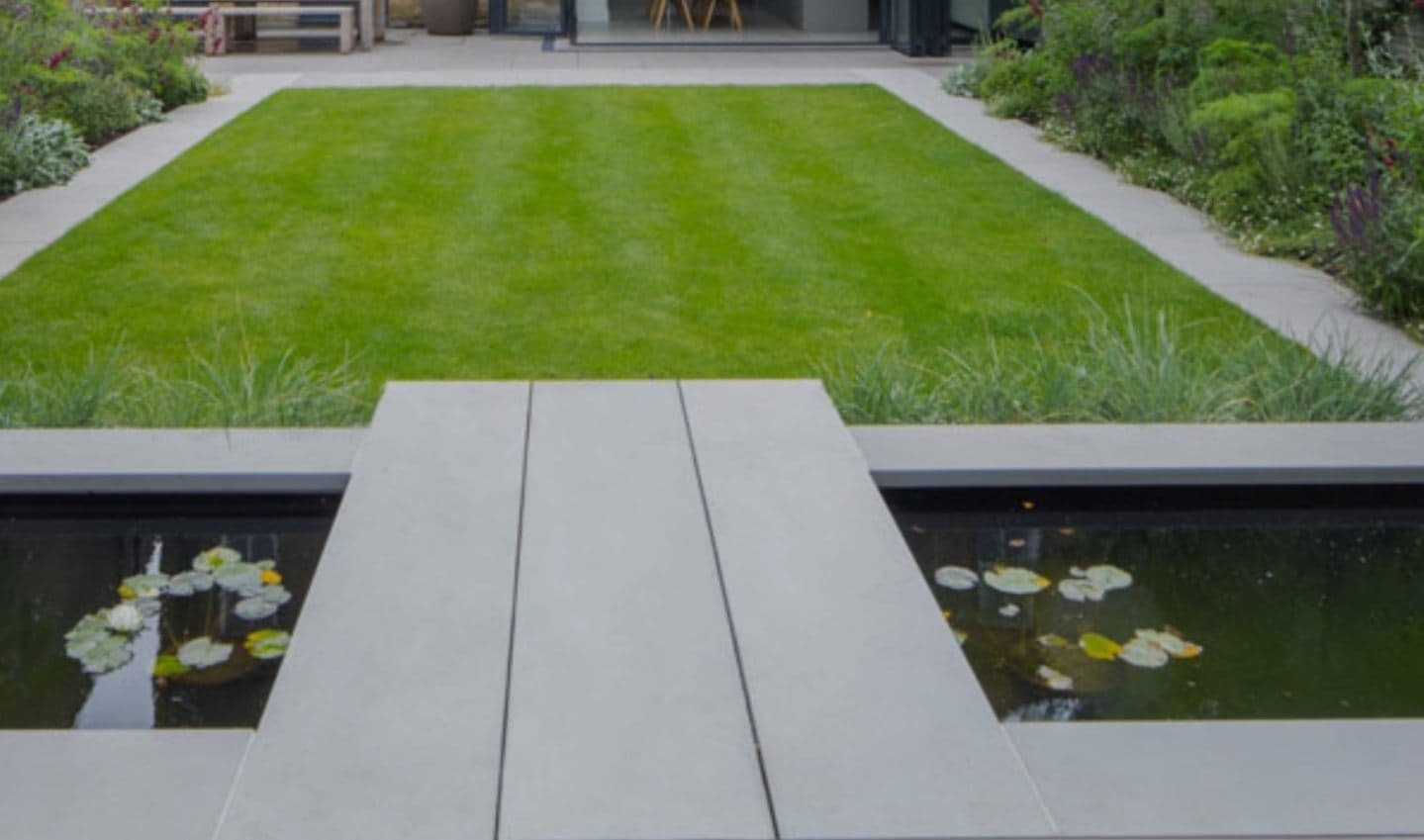 Landscaped UK garden with a lit outdoor pool at dusk — project example 2