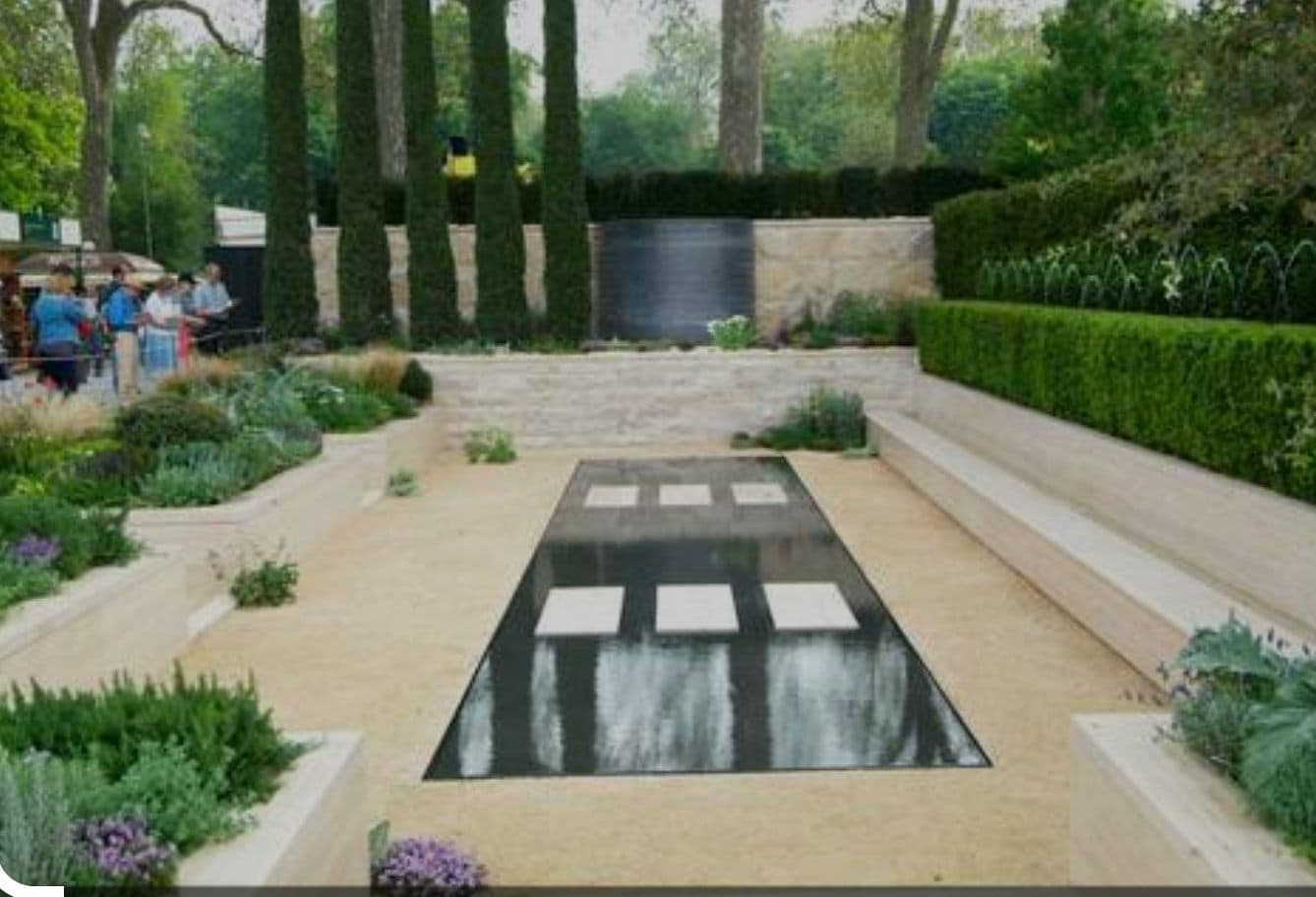 Landscaped UK garden with a lit outdoor pool at dusk — project example 1
